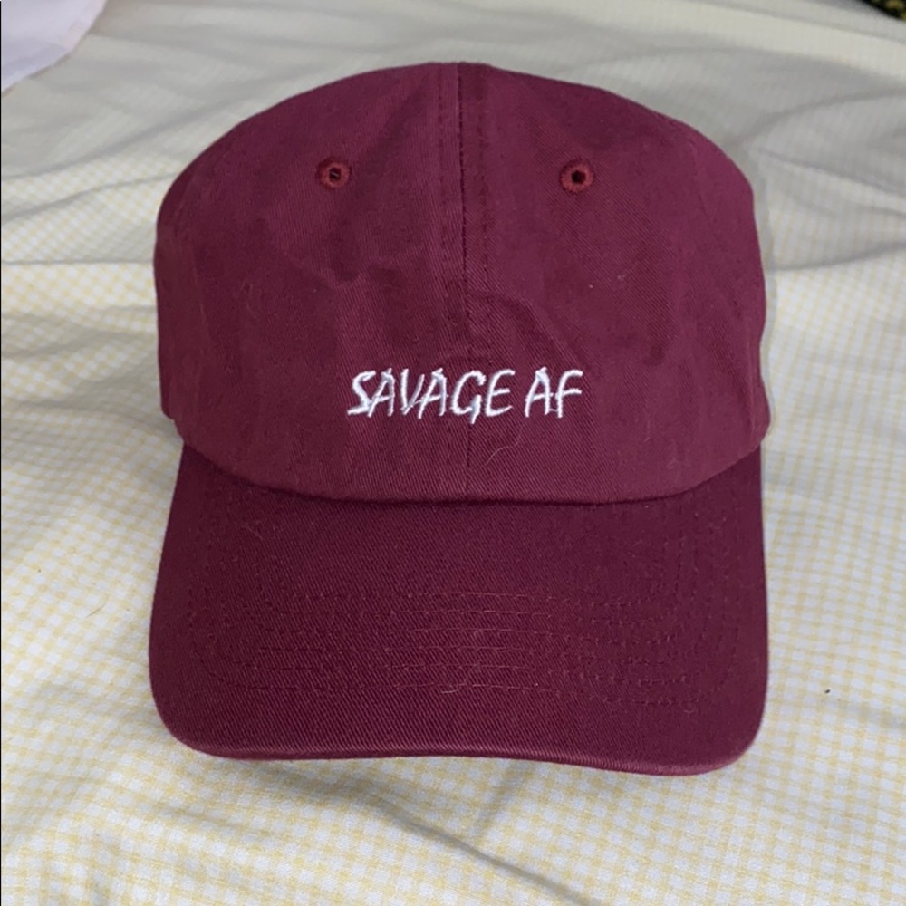 Burgundy “SAVAGE AF” adjustable strapback cap.